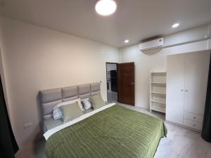 een slaapkamer met een groot bed en een groene deken bij Green Horizon in Ko Pha Ngan