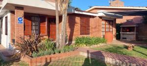 ein Backsteinhaus mit einer Palme im Hof in der Unterkunft Rincon del sol in Villa Carlos Paz