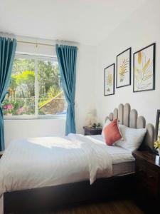 a bedroom with a bed with blue curtains and a window at Mây Hoa Tiên Relax - Villa in Xuan An