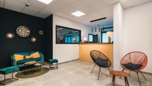 迪南水上旅馆酒店的一间等待室,配有两把椅子和一张沙发