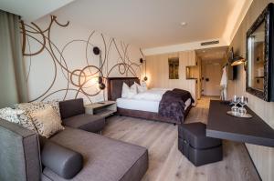 a hotel room with a bed and a couch at Boutiquehotel WEINSPITZ & Weingut STRAWANZER Donabaum in Spitz +81 photos