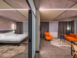 una habitación de hotel con una cama y una silla en Novotel Kraków Centrum, en Cracovia