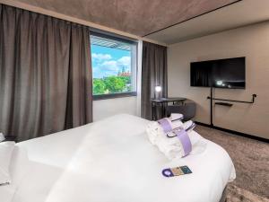 um quarto de hotel com uma cama e uma janela em Novotel Kraków Centrum na Cracóvia mais 182 fotografias
