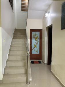 a stairway with a wooden door and a staircase with a stair railing at Moms Villa in Nedumbassery