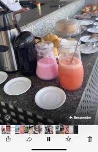 a counter top with two jars and plates with drinks at Pousada Beleleuss in Jericoacoara