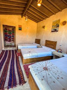 a room with four beds in a room at El Dorado Camp in Siwa