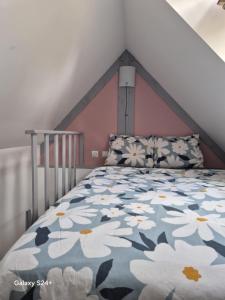 a bedroom with a bed with a floral bedspread at 17, face à la gare in Lannion