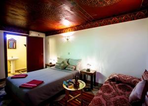 a bedroom with a large bed and a table at Riad BAB JDID in Fès +11 photos