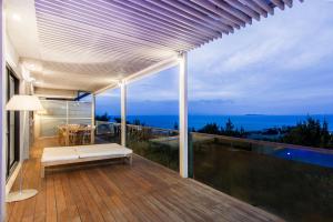balcón con banco y vistas al océano en Hidden Sanctuary In Saronida en Anavyssos