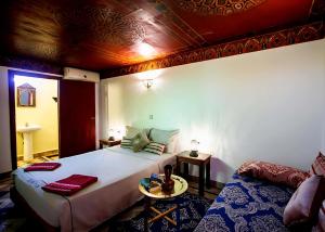 a bedroom with a large bed and a couch at Riad BAB JDID in Fès