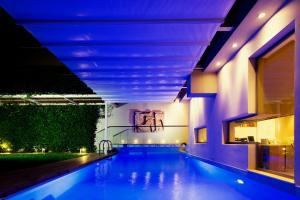 a swimming pool in a house with blue lights at Hidden Sanctuary In Saronida in Anavyssos