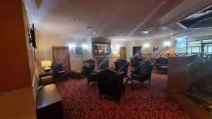 a waiting room with black chairs and a table at Wigan Oak Hotel by Belvilla in Wigan