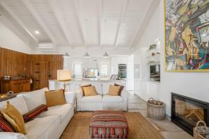 a living room with a white couch and a fireplace at Comporta Sunset Villa by Lovelystay in Comporta