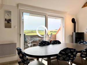 een eetkamer met een tafel en stoelen en een raam bij COC - Les Sables Blancs in Wissant