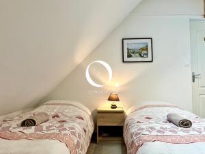 2 bedden in een zolderslaapkamer met een raam bij COC - Les Sables Blancs in Wissant