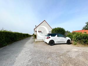 ein weißes Auto, das vor einem Haus parkt in der Unterkunft COC - Les Sables Blancs in Wissant