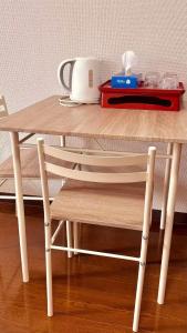 einen Holztisch mit einem Stuhl neben einem Tisch in der Unterkunft About 10 minutes to Fukuoka University Station 20 minutes to Tenjin hakata by subway in Fukuoka + 7 Fotos