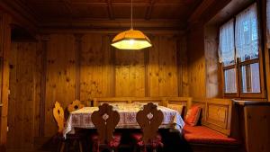 een eetkamer met een tafel en stoelen en een lamp bij Mansarda Ca Geranei in San Vito di Cadore
