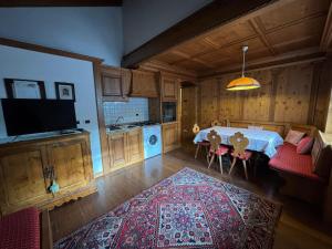 een woonkamer met een tafel en een keuken bij Mansarda Ca Geranei in San Vito di Cadore