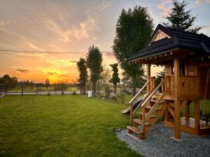 a tree house with a slide in a yard at Chochołowski Zakątek in Chochołów