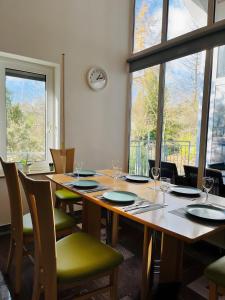 a dining room with a table with chairs and windows at Ferienwohnung Ambiente - 3 Zimmer in Bad Säckingen