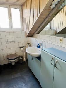 a bathroom with a sink and a toilet and stairs at Ferienwohnung Ambiente - 3 Zimmer in Bad Säckingen