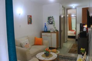 una sala de estar con un sofá y una mesa en Purespace Luxury, en Nairobi