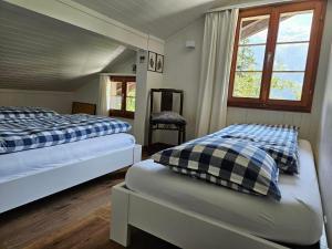 ein Schlafzimmer mit zwei Betten und einem Fenster in der Unterkunft Chalet Tannegüetli in Grindelwald