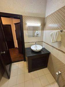 a bathroom with a sink and a mirror at Crescent Hotel in Peshawar