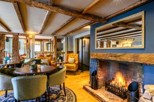 un soggiorno con camino, tavoli e sedie di The St George and Dragon by Innkeeper's Collection a Topsham