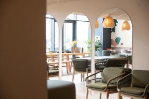 a dining room with chairs and a table and windows at ECLA Genève Archamps in Archamps
