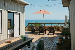 eine Terrasse mit Tisch und Stühlen und einem Sonnenschirm in der Unterkunft Mountain Magic Hoekwil in Wilderness