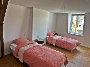 two beds with red sheets in a room with a window at Cabinet de rêveries #2 in Cassel