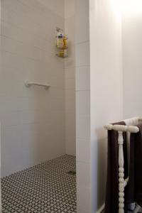 ein Badezimmer mit Dusche mit schwarz-weißen Fliesen in der Unterkunft Le Cabanon in Cosne Cours sur Loire + 13 Fotos