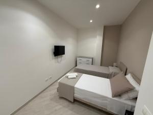 a bedroom with a bed and a tv on the wall at Maison Rovaga in Ispica