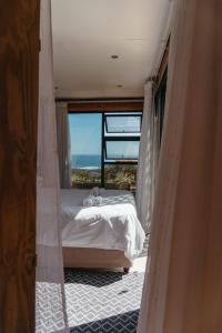 ein Schlafzimmer mit einem Bett mit Blick auf das Meer in der Unterkunft Mountain Magic Hoekwil in Wilderness