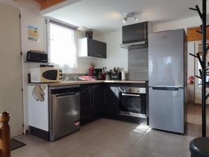 a kitchen with a stainless steel refrigerator and appliances at La pointe du Chay in Le Pavé