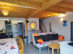 a living room with a couch and a kitchen at La pointe du Chay in Le Pavé +6 photos
