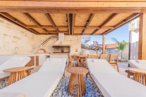 Una cocina al aire libre con techos de madera y mesas y sillas de madera. en Villa Kirke with private swimming pool, en Próvarma