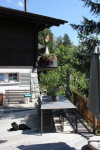 Eine Terrasse mit einem Tisch und einem Hund, der auf dem Boden schläft. in der Unterkunft Chalet Tannegüetli in Grindelwald