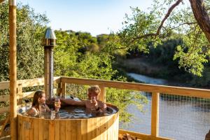 a boy and a girl sitting in a hot tub at AfriCamps at Bonamanzi Game Reserve in Hluhluwe +12 photos