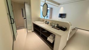 XingpingにあるBanshanyue Hotel, Yangshuoの洗面台と鏡のある白いバスルーム