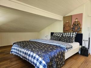 ein Schlafzimmer mit einem Bett mit einer blau-weißen Decke in der Unterkunft Chalet Tannegüetli in Grindelwald + 16 Fotos