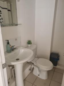 a white bathroom with a toilet and a sink at Departamento elsa ramitez in Ovalle