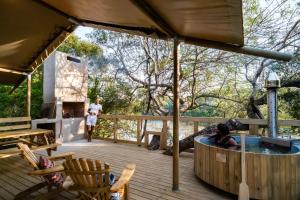 a house with a hot tub on a deck at AfriCamps at Bonamanzi Game Reserve in Hluhluwe