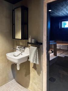 ein Badezimmer mit Waschbecken und Spiegel in der Unterkunft Romantic cottage with sauna in Porvoo + 24 Fotos