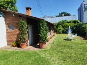 ein Backsteinhaus mit einem Garten mit Pflanzen und einem Tisch in der Unterkunft Quincho in Mar del Plata