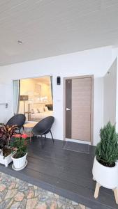 un porche con 2 sillas y una mesa y un dormitorio en Nong Nuey Rooms, en Ko Samed