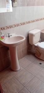 une salle de bain avec un lavabo et des toilettes dans l'établissement Departamento con Estacionamiento Tacna, à Tacna