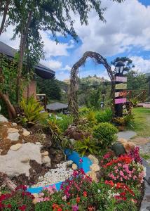 ein Garten mit einem Bogen und Blumen in der Unterkunft Pousada Chales da Mantiqueira - Campos do Jordão in Campos do Jordão + 288 Fotos